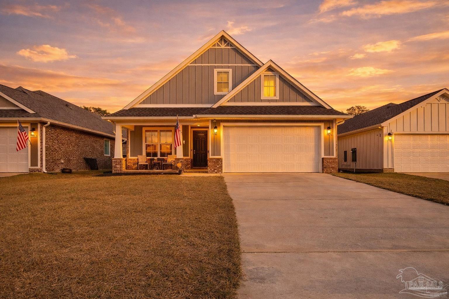 3838 Ranch Road Pace, FL 32571 - Photo 2 of 42 a front view of a house with a yard and garage