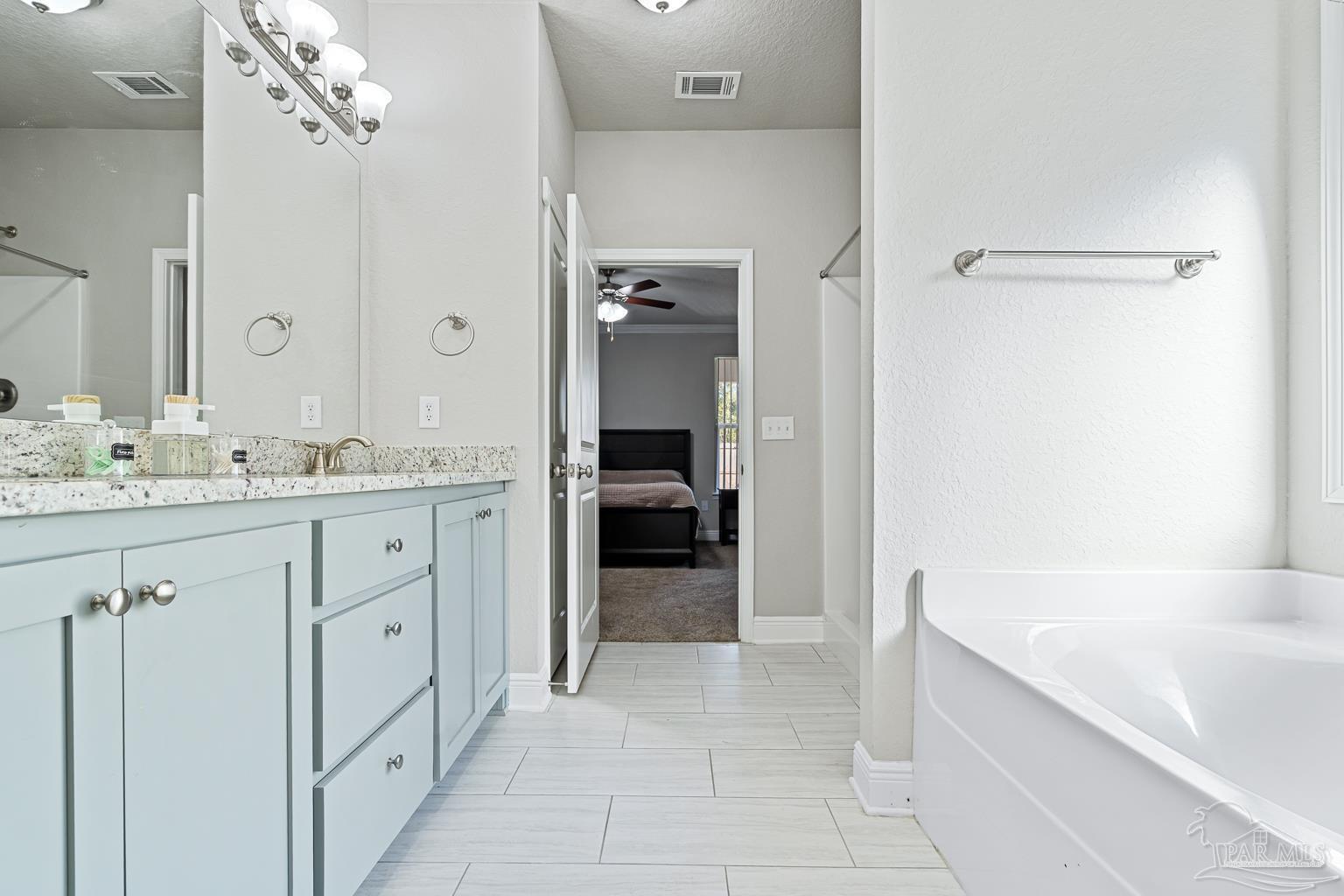 3838 Ranch Road Pace, FL 32571 - Photo 26 of 40 a bathroom with a sink a vanity and a tub
