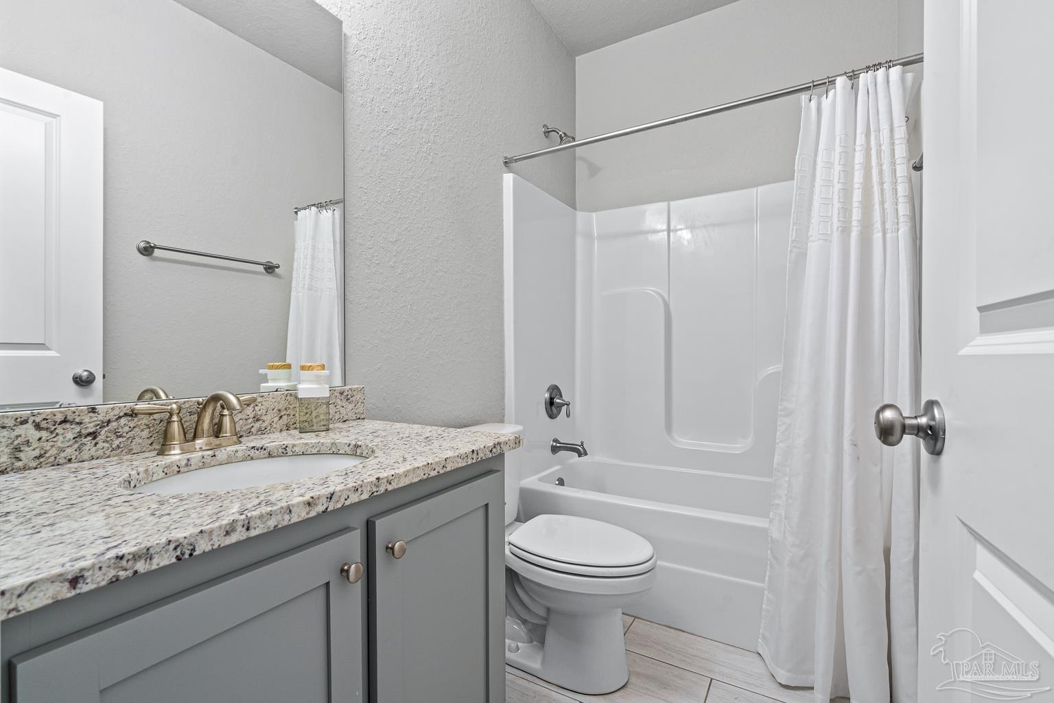 3838 Ranch Road Pace, FL 32571 - Photo 29 of 40 a bathroom with a granite countertop sink toilet and shower