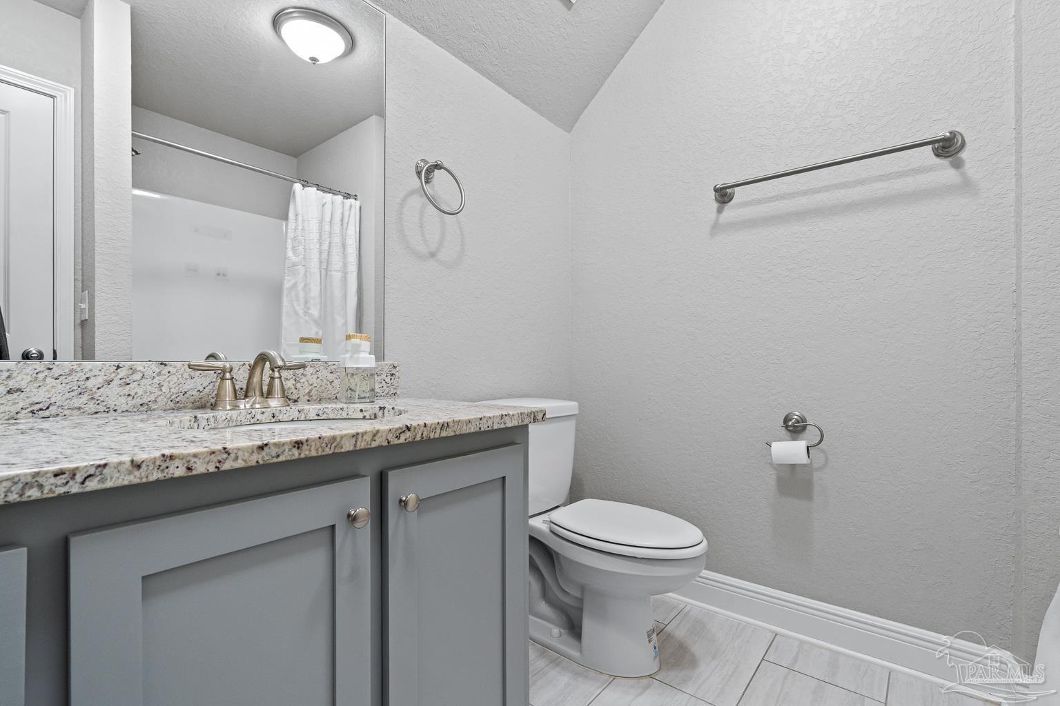 3838 Ranch Road Pace, FL 32571 - Photo 34 of 42 a bathroom with a granite countertop sink a toilet and a mirror
