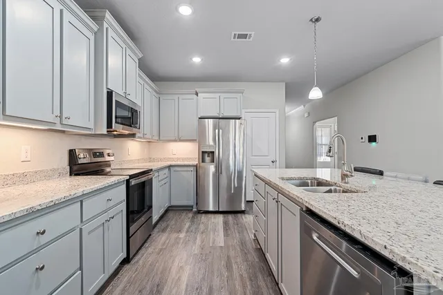 a kitchen with stainless steel appliances granite countertop a sink stove and refrigerator