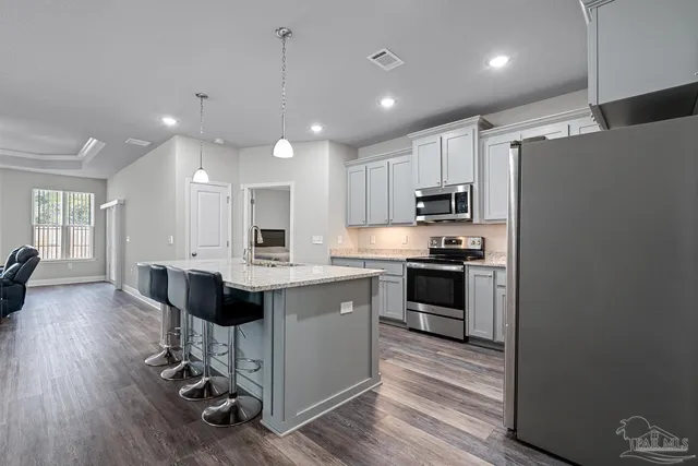 a kitchen with kitchen island white cabinets and stainless steel appliances