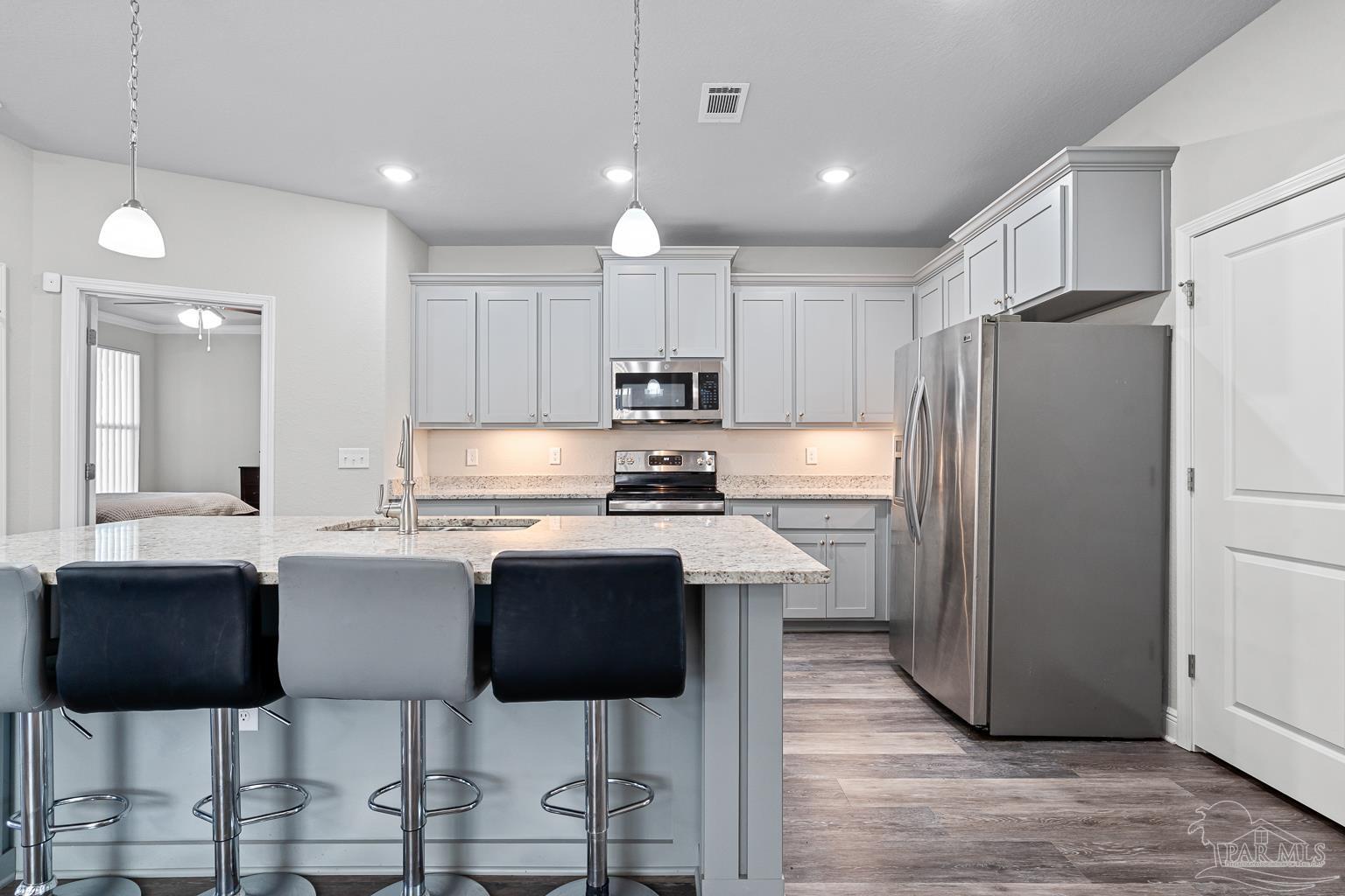 3838 Ranch Road Pace, FL 32571 - Photo 9 of 40 a kitchen with stainless steel appliances granite countertop a stove refrigerator sink cabinets dining table and chairs