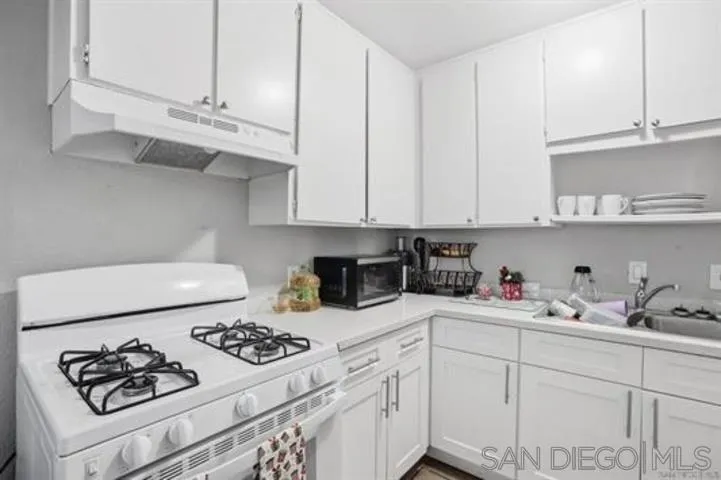 829 Grand Avenue Spring Valley, CA 91977 - Photo 10 of 19 a kitchen with white cabinets and white appliances