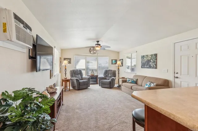 a living room with furniture ceiling fan and a window