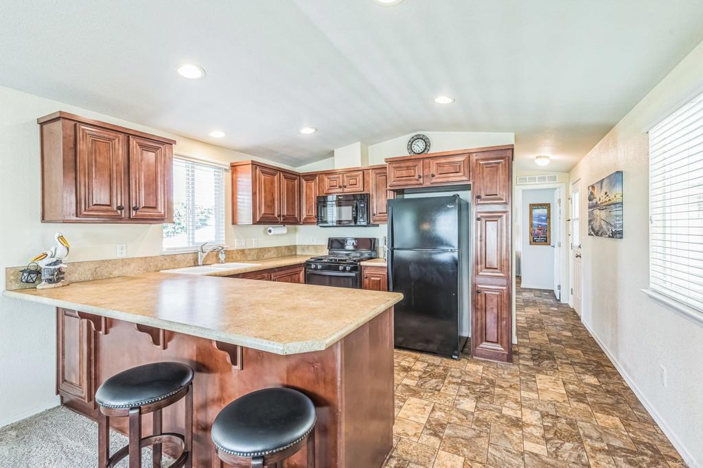 699 North Vulcan Avenue, Unit 17 Encinitas, CA 92024 - Photo 7 of 17 a kitchen with stainless steel appliances granite countertop a refrigerator a stove a sink and a cabinets