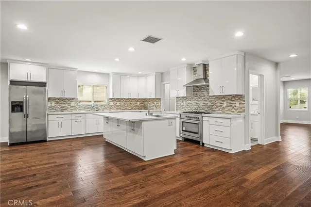 a kitchen with white cabinets and stainless steel appliances