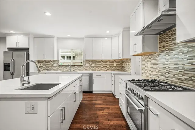 a kitchen with granite countertop a sink stove and cabinets