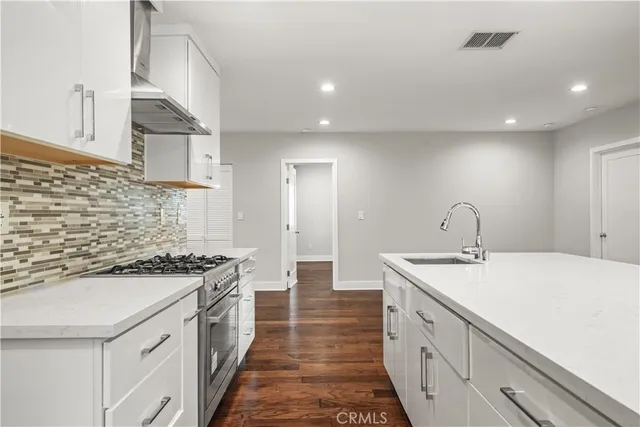 a kitchen with stainless steel appliances a sink stove and cabinets