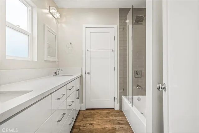 a spacious bathroom with a double vanity sink a mirror and a bathtub