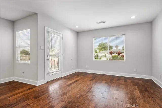 an empty room with wooden floor and window