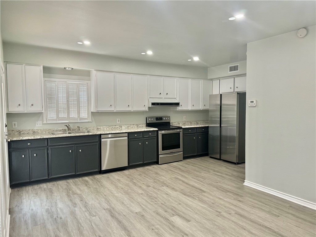1805 3rd Street Corpus Christi, TX 78404 - Photo 6 of 26 a large kitchen with stainless steel appliances granite countertop a refrigerator and a stove top oven