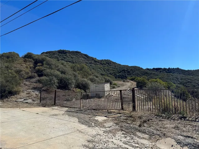 a view of a dry yard with wooden fence