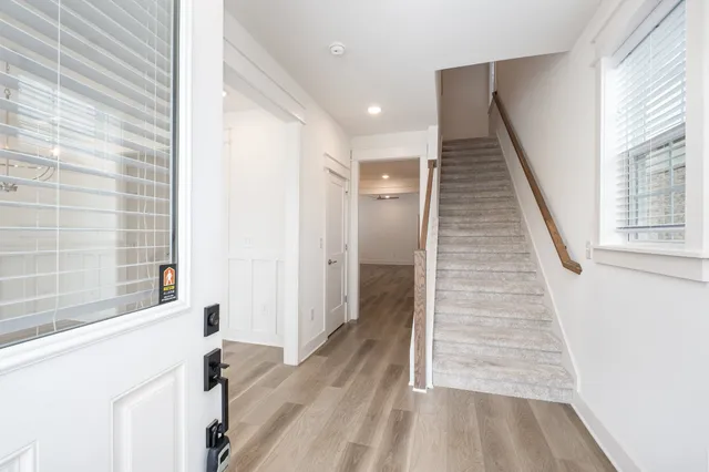 a view of a hallway with wooden floor and staircase