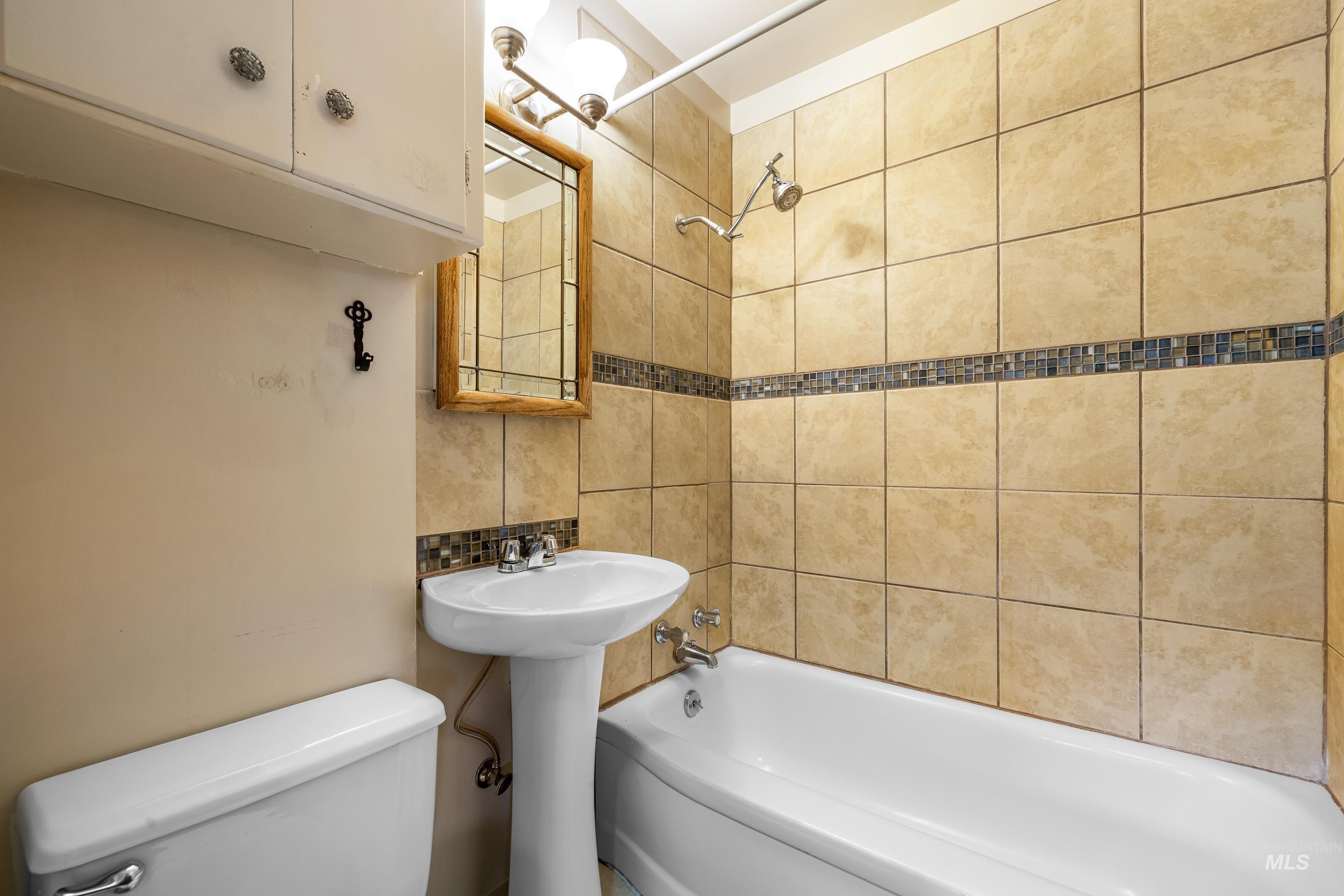 708 South Phillippi Street Boise, ID 83705 - Photo 19 of 25 Bathroom featuring a pedestal sink, white toilet, and a bathtub with a shower