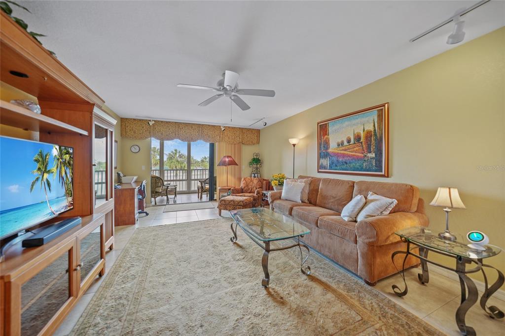 175 Kings Highway, Unit 226 Punta Gorda, FL 33983 - Photo 6 of 41 a living room with furniture a flat screen tv and a floor to ceiling window