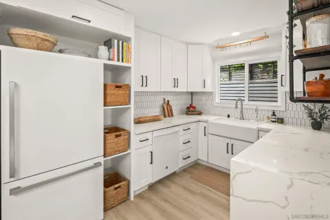 a kitchen with white cabinets and white appliances