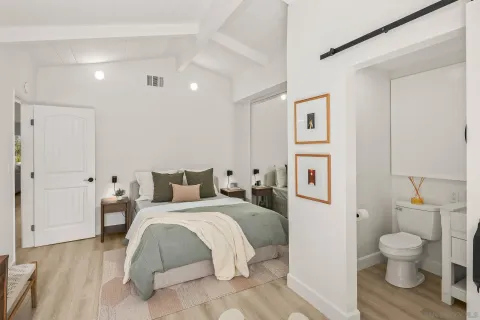 a spacious bedroom with a bed and a view of bathroom
