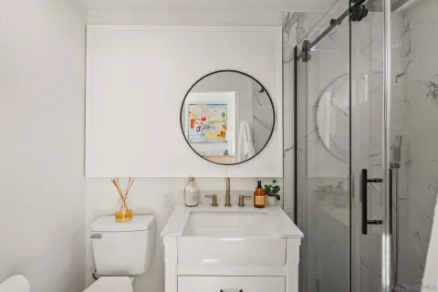 a bathroom with a sink vanity mirror and toilet