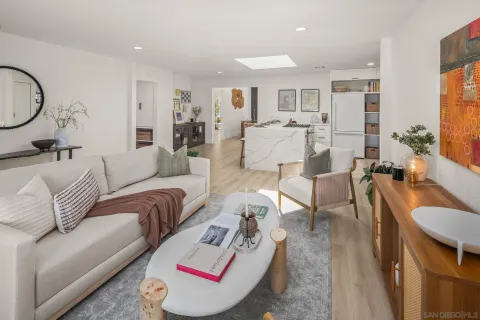 a living room with furniture kitchen view and a large window