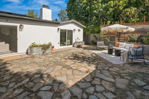 a view of a patio with table and chairs potted plants with wooden floor and fence