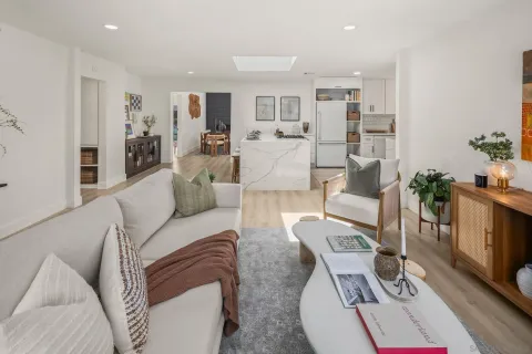 a living room with furniture and a dining table with kitchen view