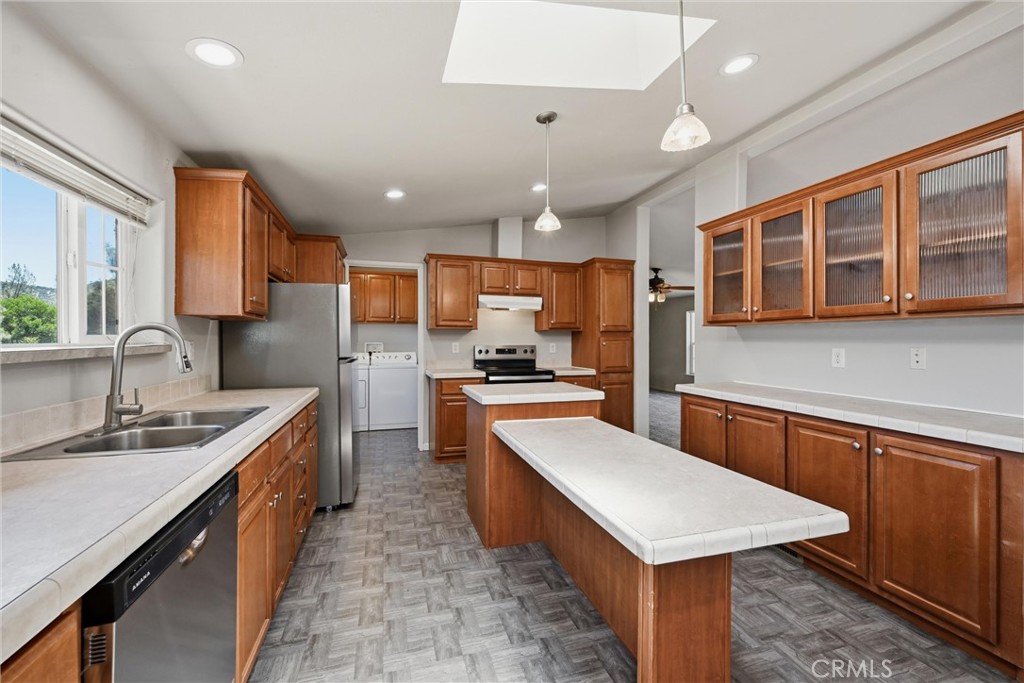 2860 Spring Valley Road Clearlake Oaks, CA 95423 - Photo 15 of 38 a large kitchen with stainless steel appliances kitchen island granite countertop a large kitchen island a sink a stove and a refrigerator