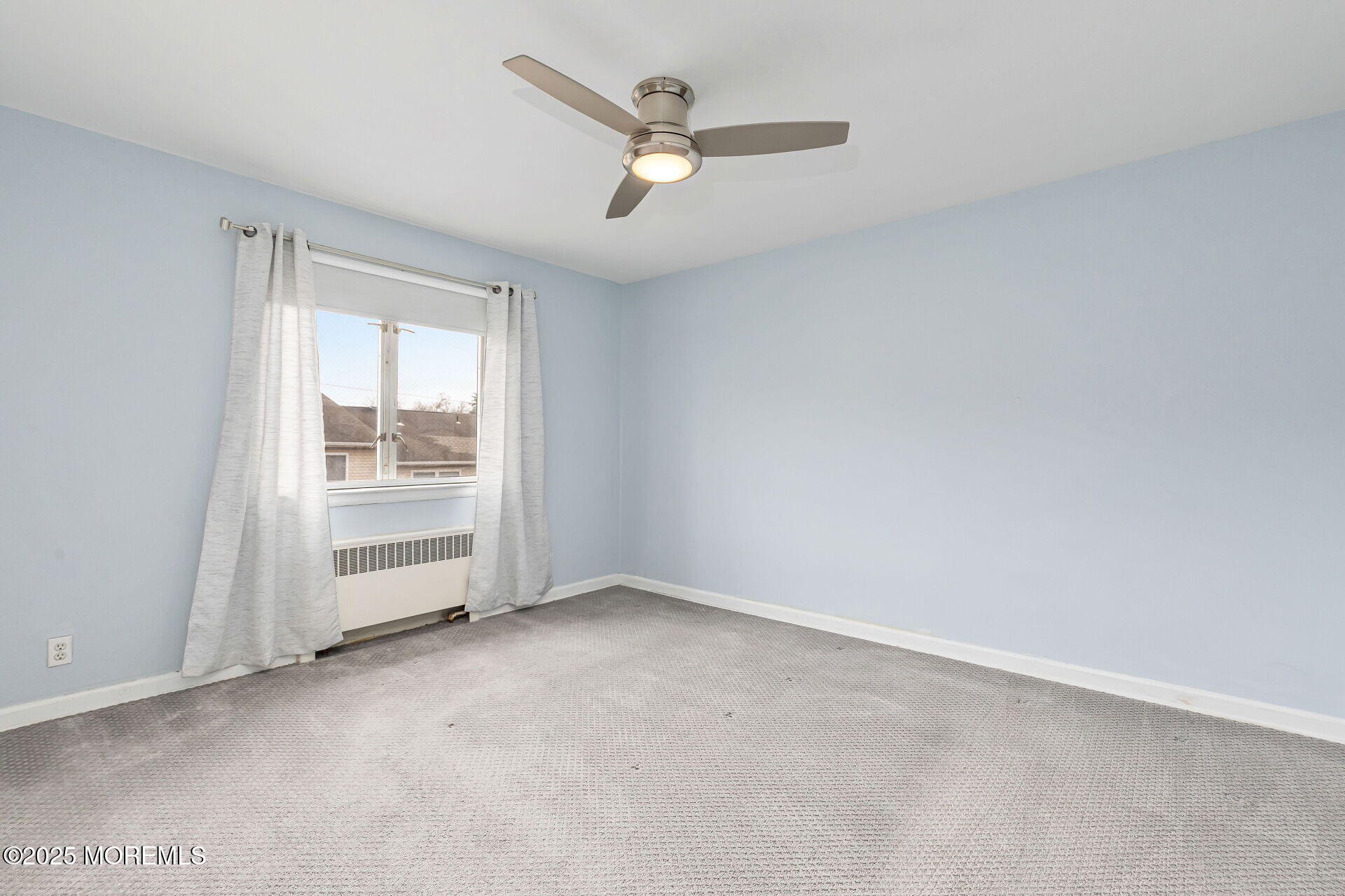 293 Spring Street, Unit 15D Red Bank, NJ 07701 - Photo 13 of 28 an empty room with a ceiling fan and window