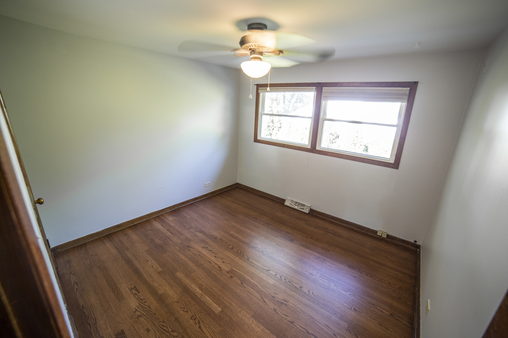 1222 Hickory Road Homewood, IL 60430 - Photo 12 of 29 an empty room with wooden floor ceiling fan and window