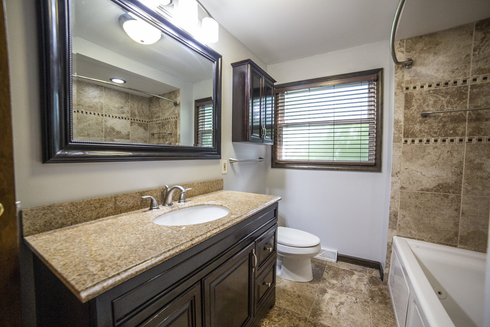1222 Hickory Road Homewood, IL 60430 - Photo 16 of 29 a bathroom with a granite countertop sink a mirror a toilet and a window