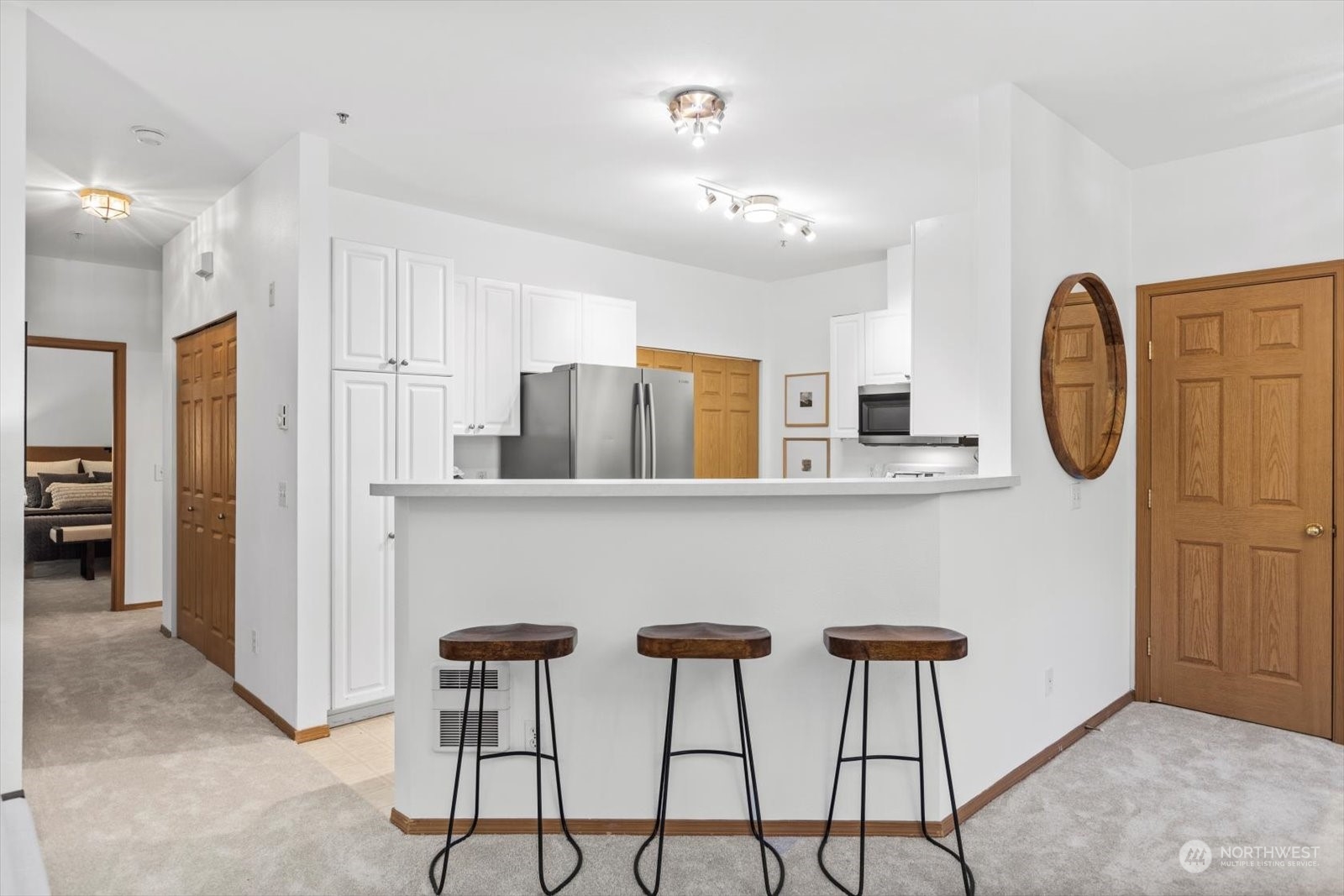 17757 134th Lane Southeast Renton, WA 98058 - Photo 11 of 38 a kitchen with stainless steel appliances granite countertop a dining table chairs and a refrigerator