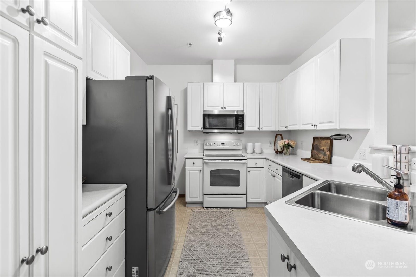 17757 134th Lane Southeast Renton, WA 98058 - Photo 13 of 38 a kitchen with white cabinets and stainless steel appliances
