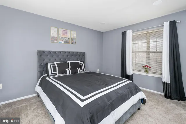 a bed sitting in a bedroom next to a window