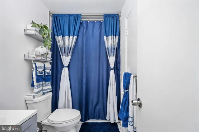 a bathroom with a toilet a sink and curtain