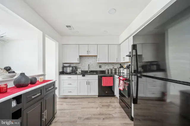 a kitchen with granite countertop a sink cabinets and stainless steel appliances