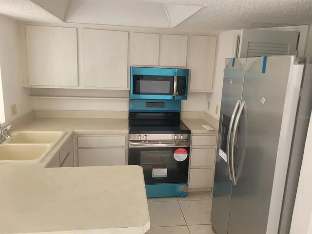 a kitchen with a refrigerator and cabinets