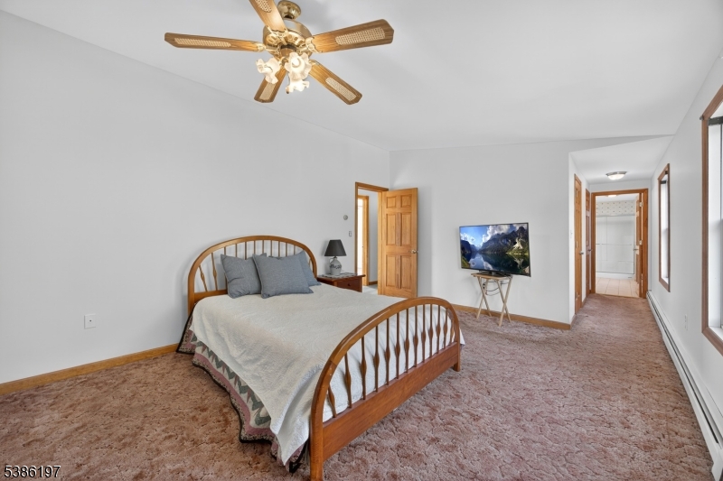 61 Coykendall Road Wantage, NJ 07461 - Photo 19 of 43 a bedroom with a bed next to a window with a chandelier