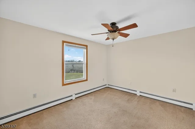 an empty room with a window and a fan