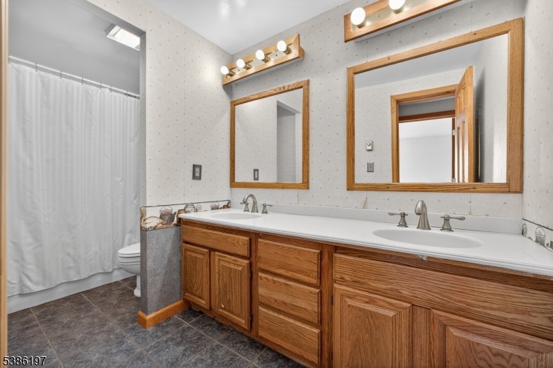 61 Coykendall Road Wantage, NJ 07461 - Photo 27 of 43 a bathroom with a double vanity sink and a mirror