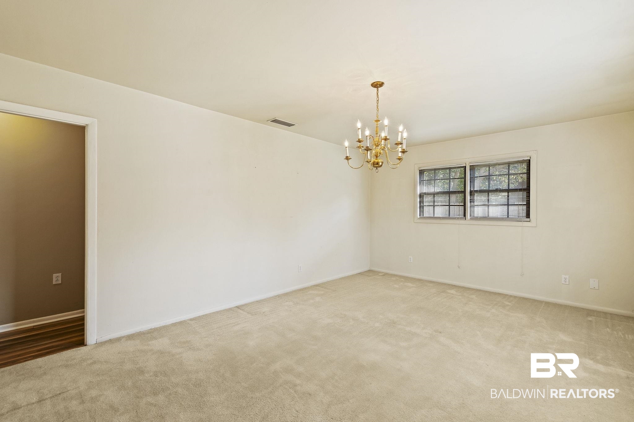 4366 Barden Avenue Mobile, AL 36619 - Photo 34 of 40 Carpeted empty room featuring an inviting chandelier