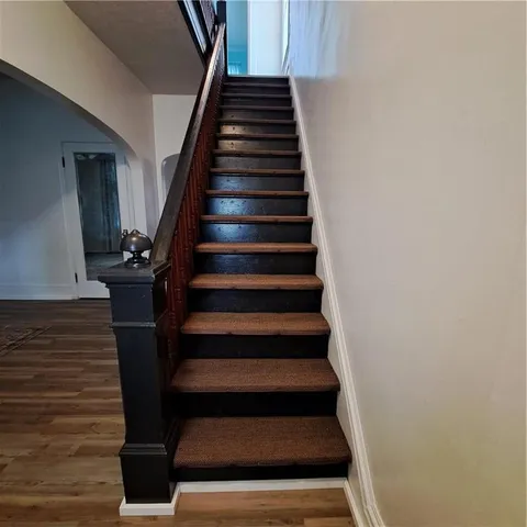 a view of a hallway with wooden floor and staircase