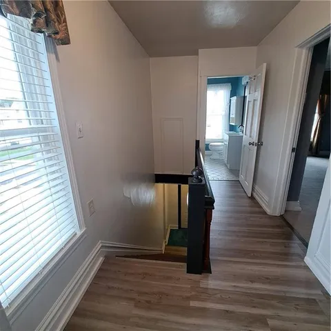 a view of a hallway with wooden floor and staircase