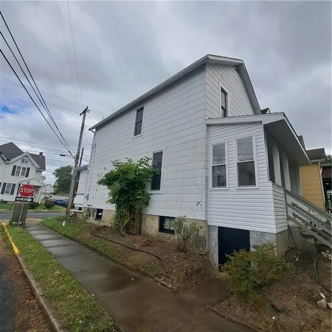 a view of a house with backyard and sitting area