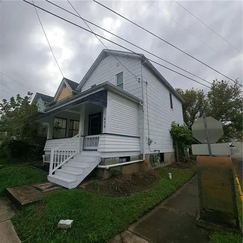 a small barn with a large tree in front of it