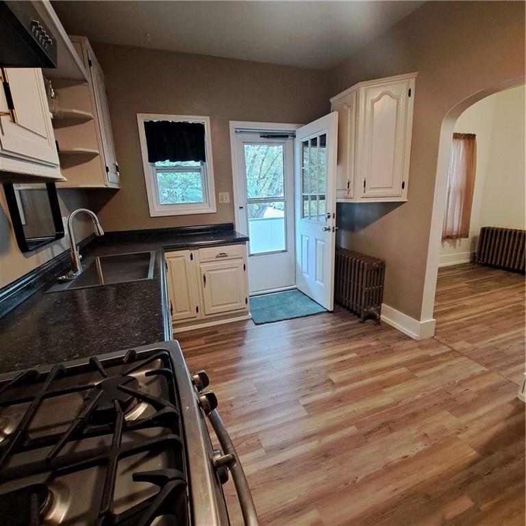 439 Longfellow Street Vandergrift, PA 15690 - Photo 5 of 49 a kitchen with wooden floors a stove and a microwave