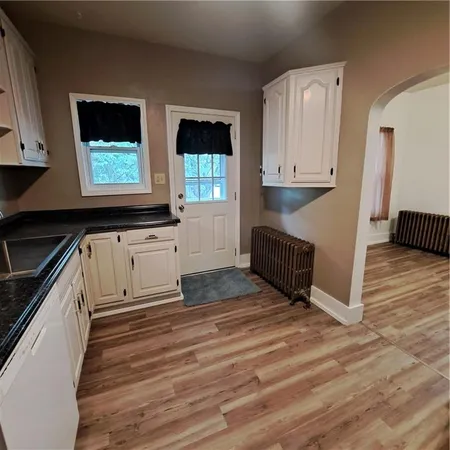 a kitchen with granite countertop a stove a sink and a microwave