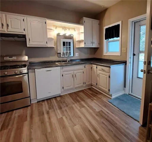 a kitchen with granite countertop wooden cabinets stainless steel appliances and a window
