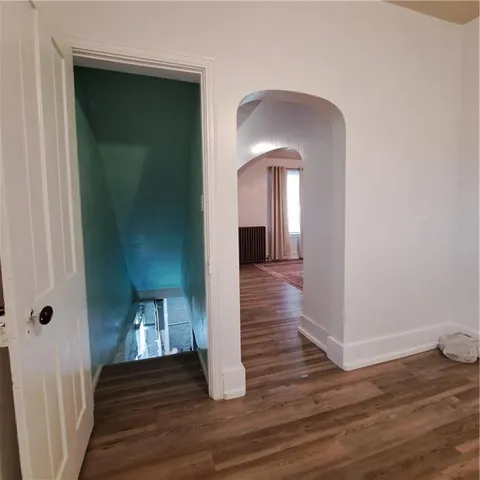 a view of a hallway with wooden floor and stairs