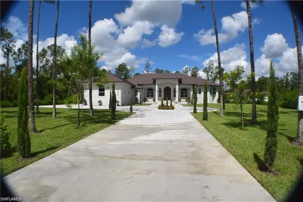 a front view of a house with a yard and potted plants
