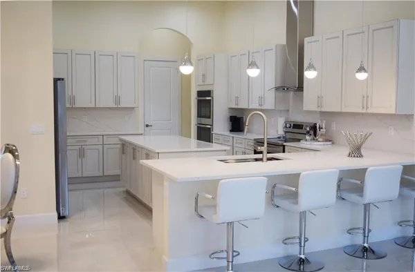 a kitchen with kitchen island granite countertop a sink cabinets and chairs